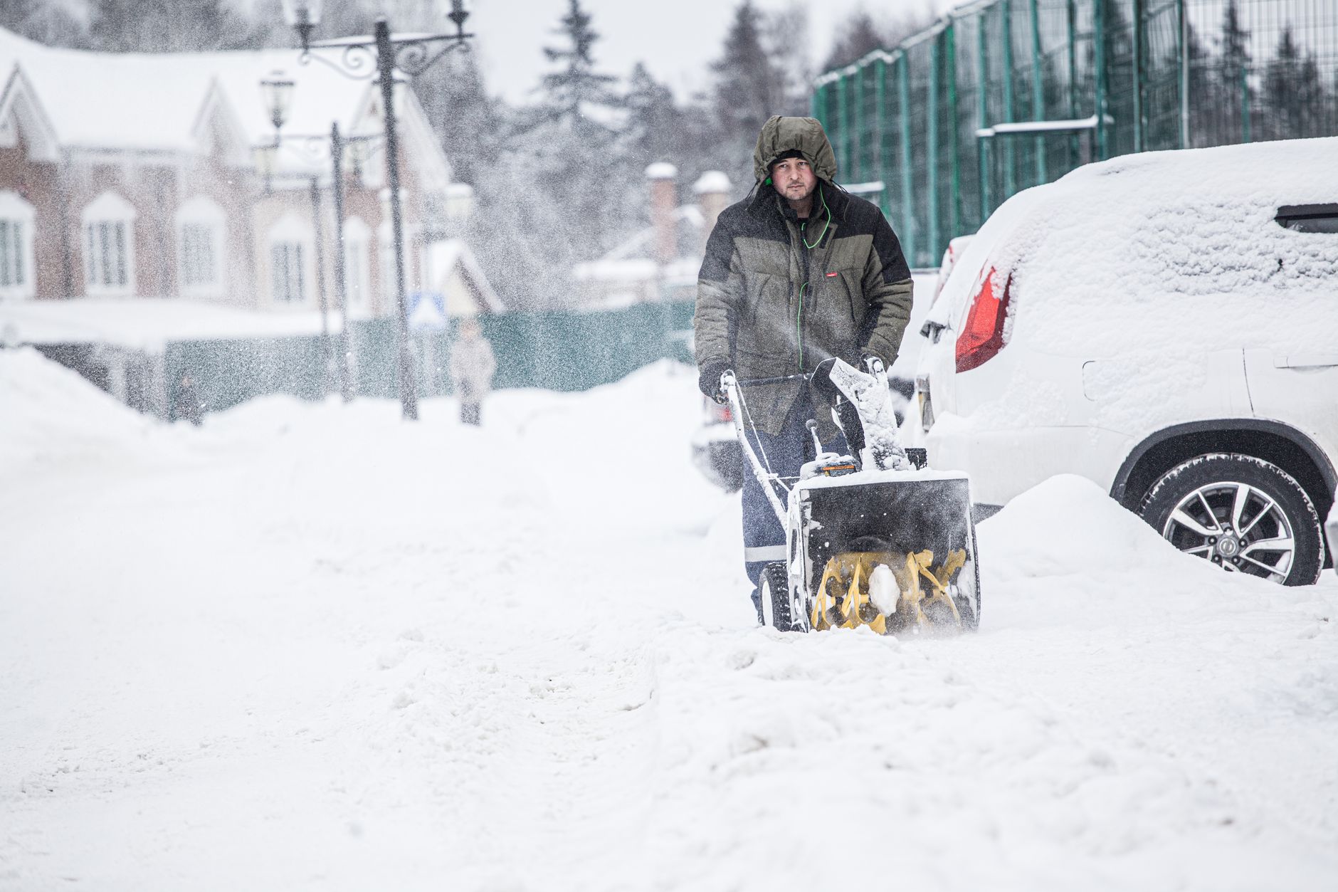 Best snow blower: a man clearing a snowy street with a snow blower
