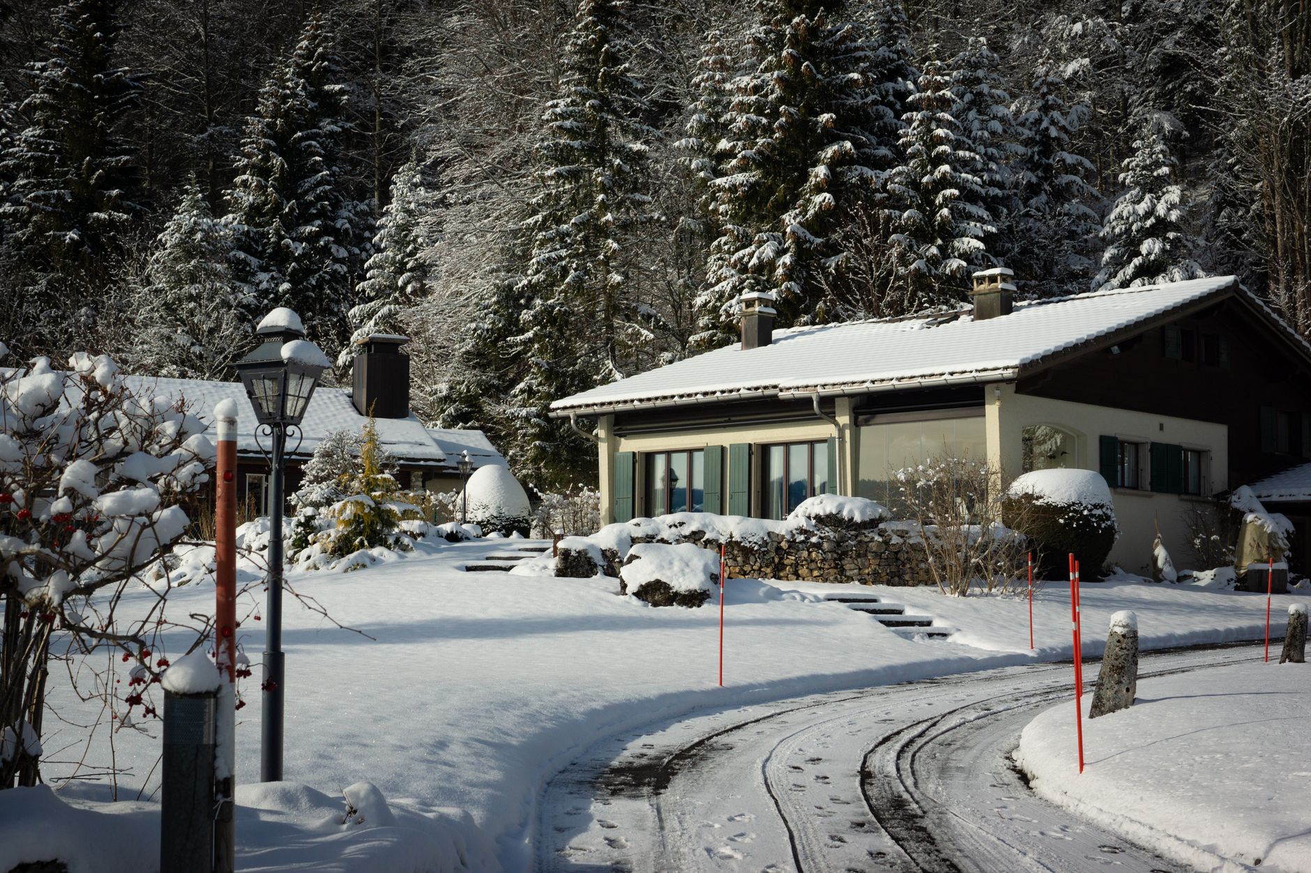 A snow-covered driveway in front of a house
