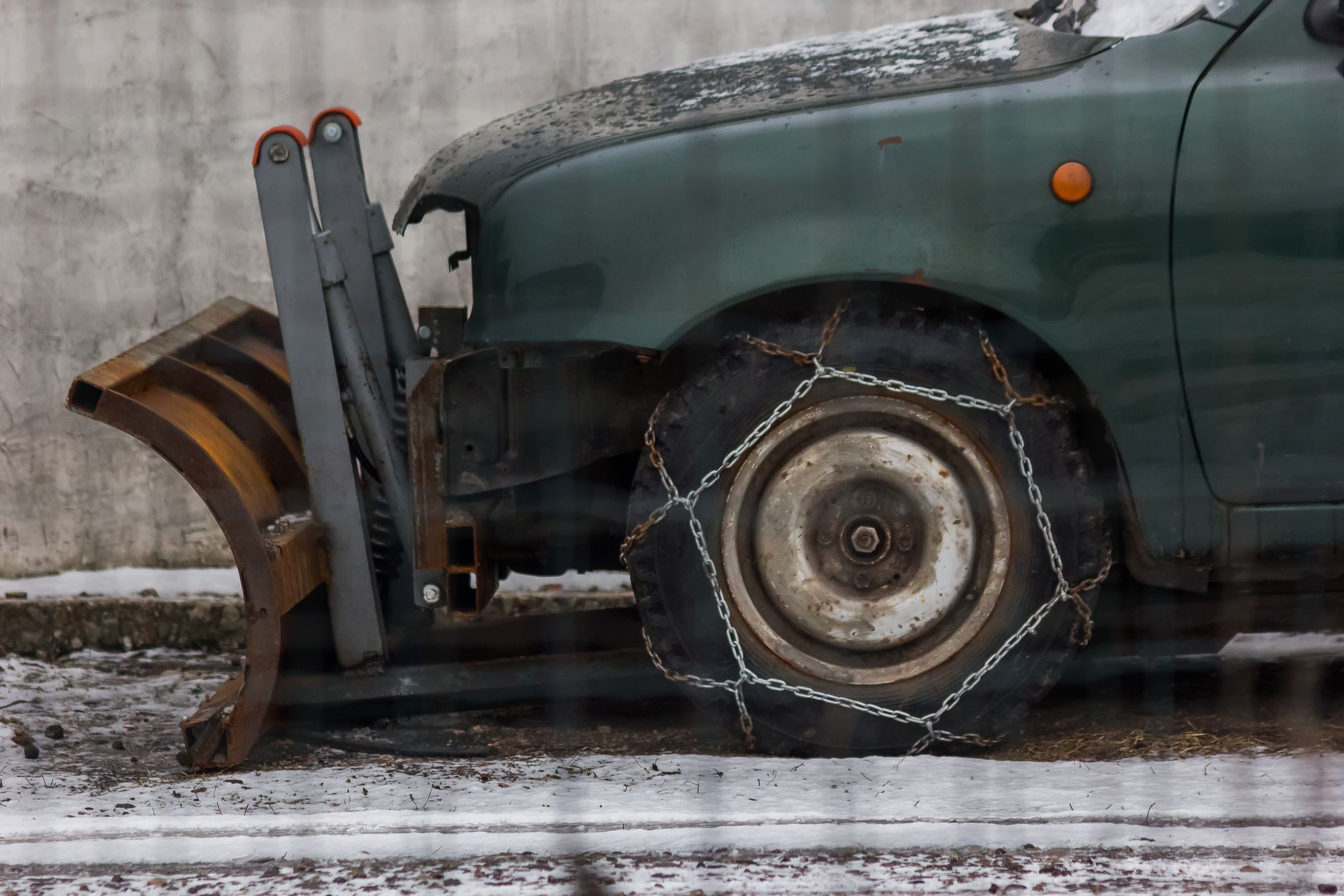 A tire chain on a plow truck wheel