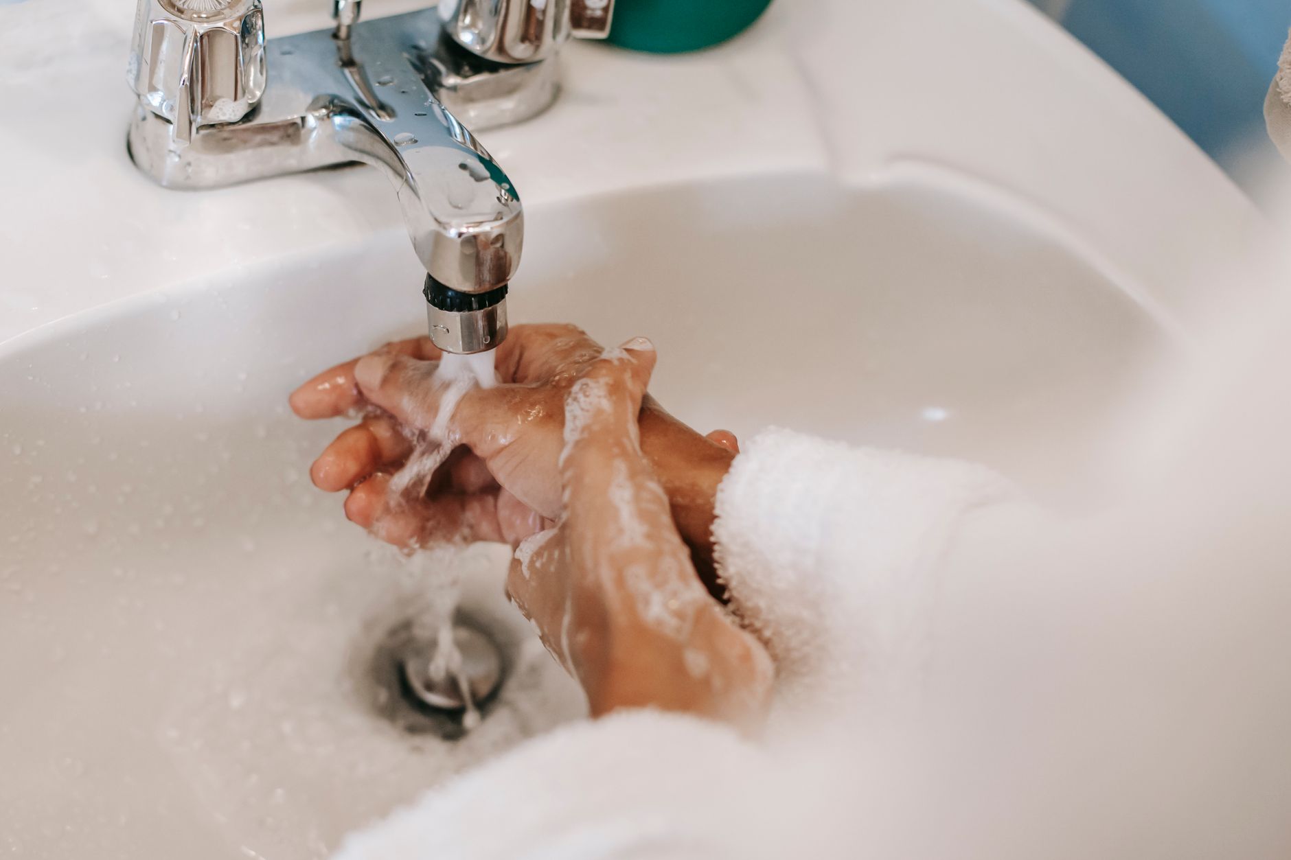 Washing hands with soap under a faucet