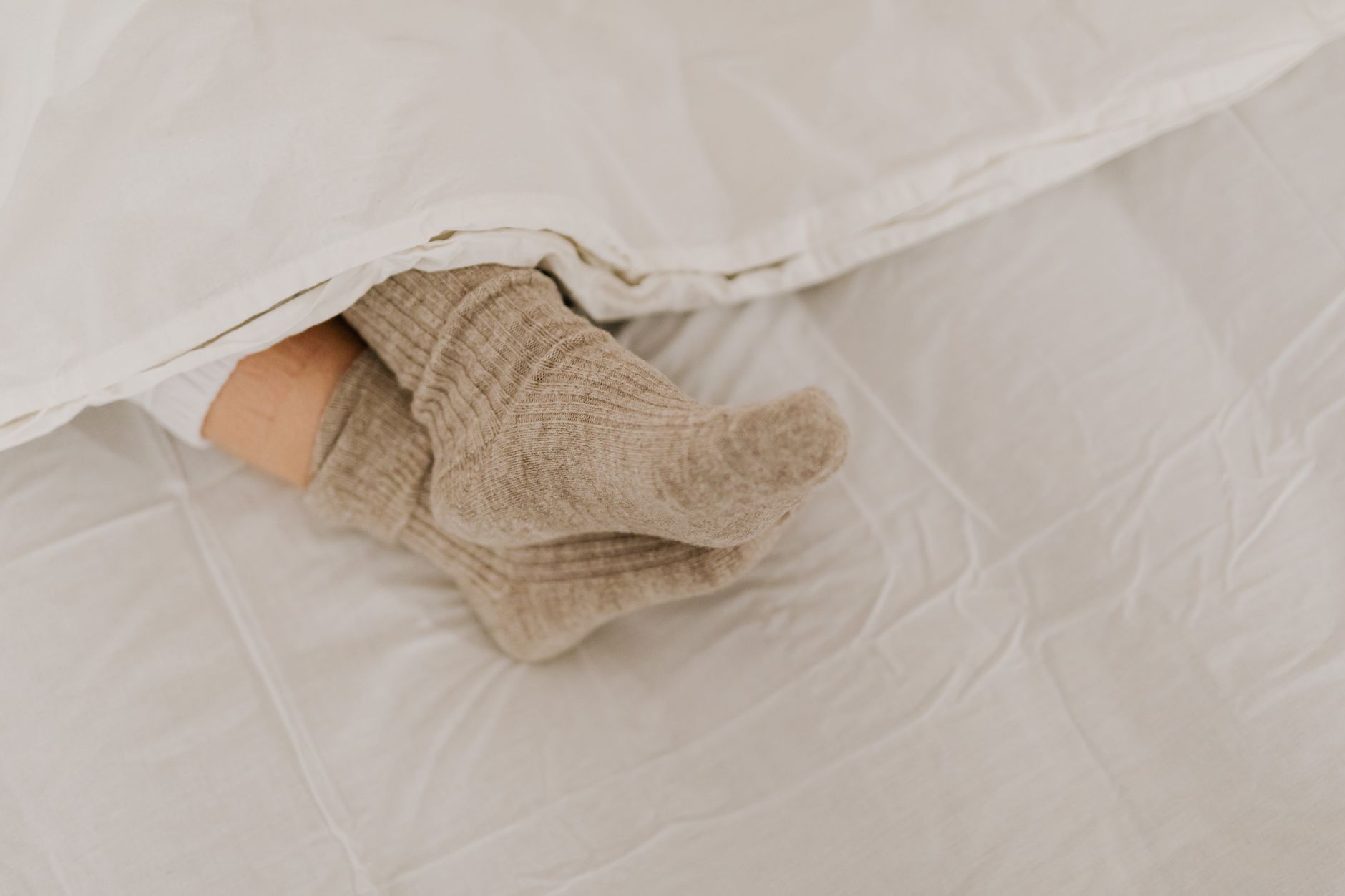 Best sock aid: feet in wool socks on a bed