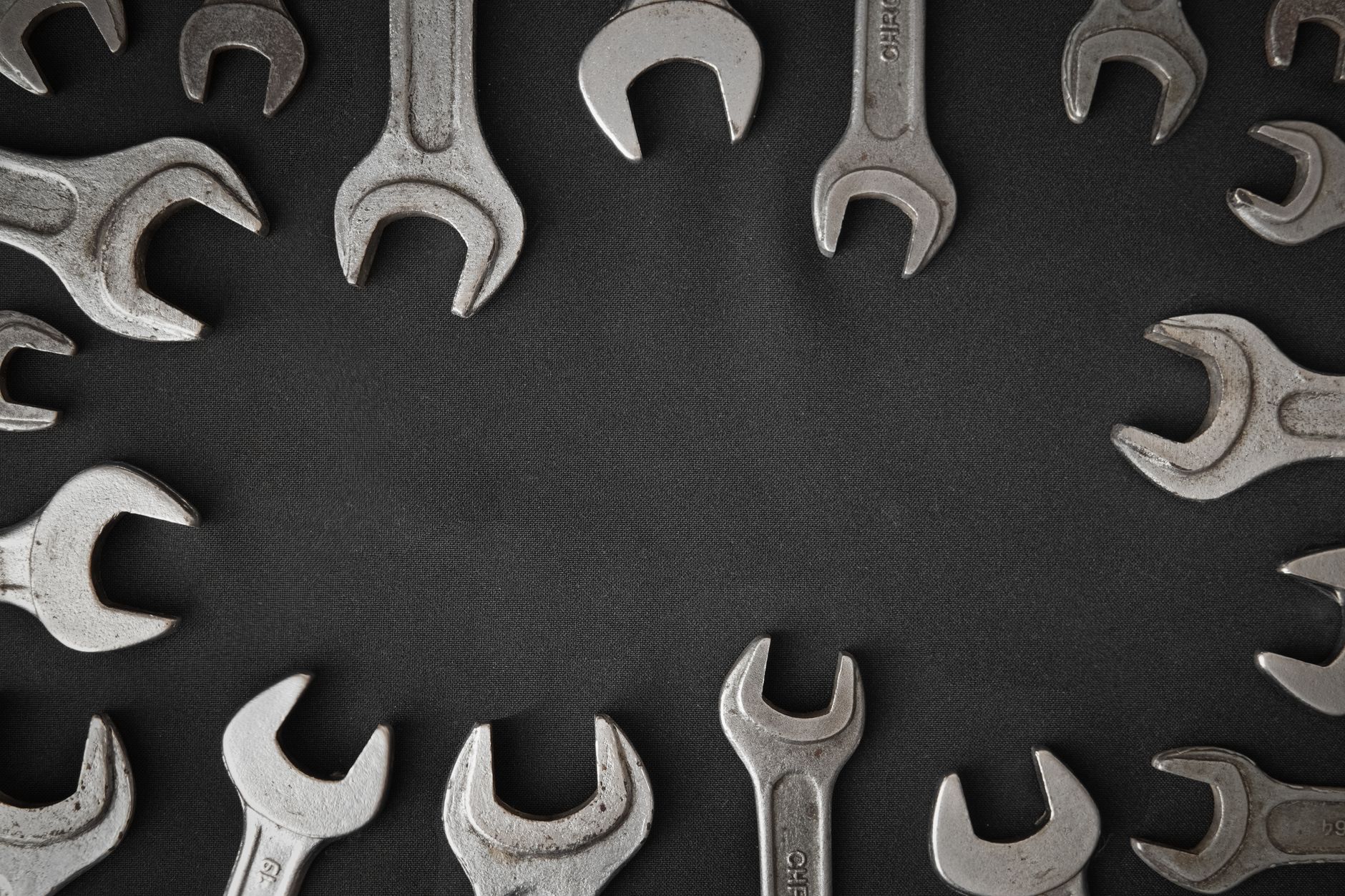 Wrenches and hand tools laid out on a table