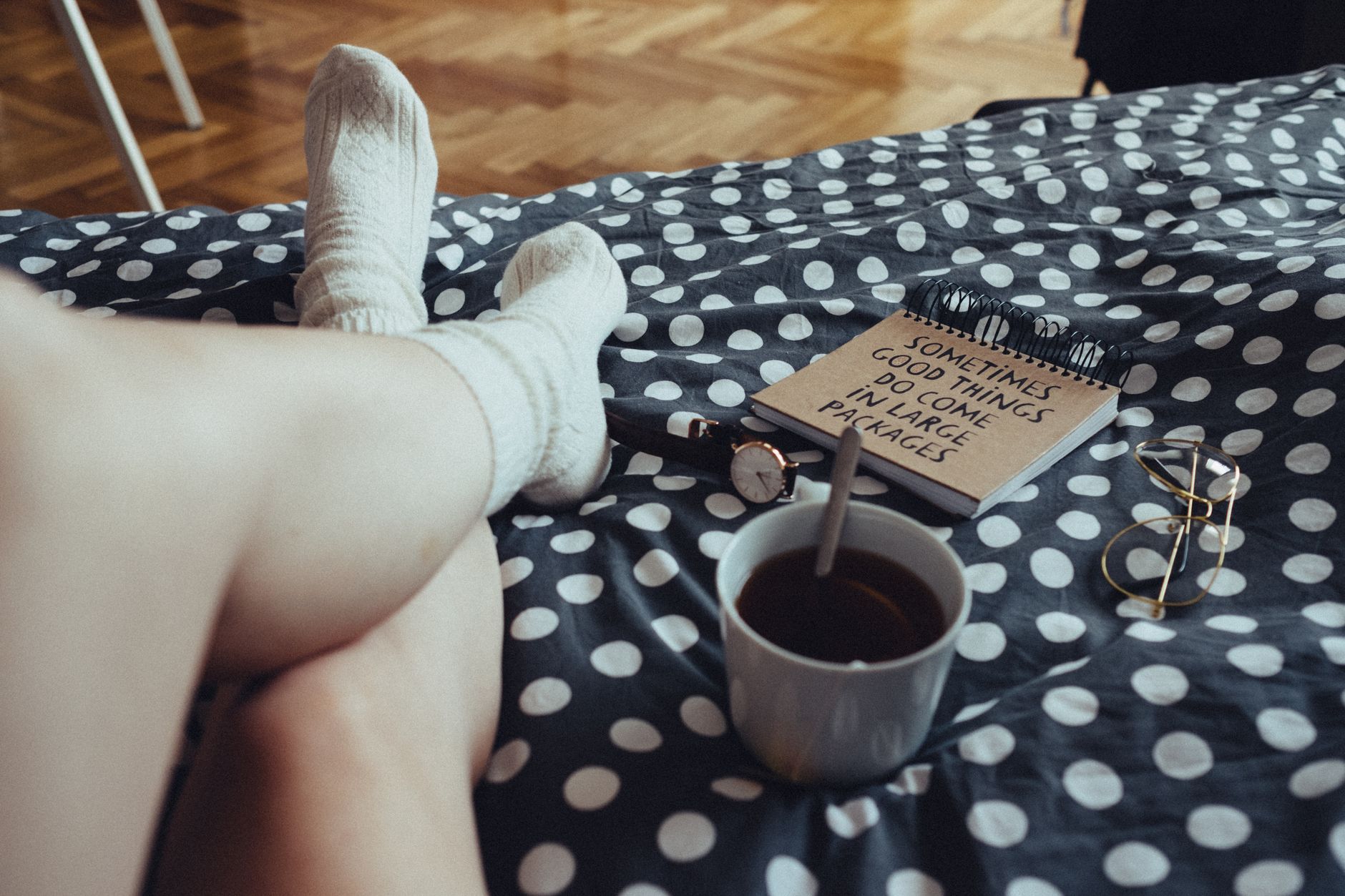 Feet in wool socks on a bed