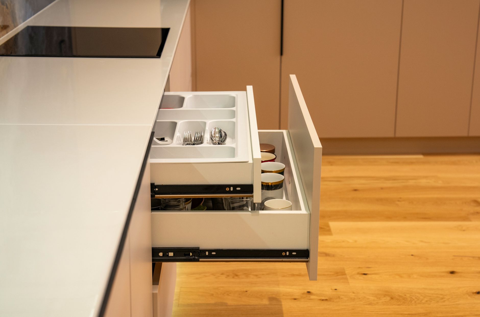 An open kitchen drawer with a utensil tray