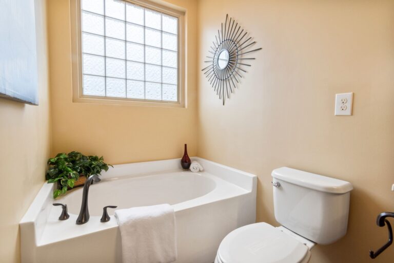Best spin scrubber: a bathroom with a corner tub and glass block window