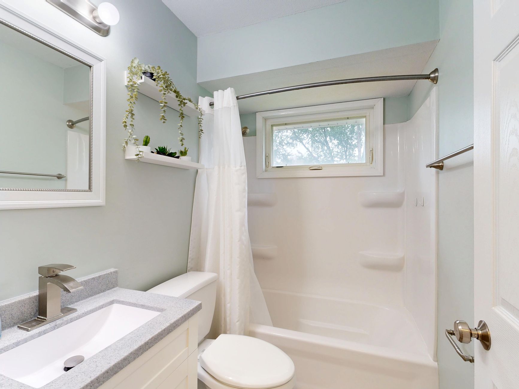 A small bathroom with a tub and window