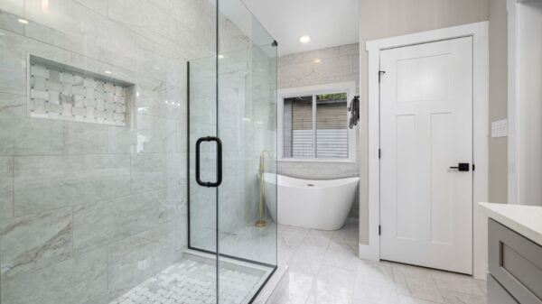 A glass shower beside a freestanding tub