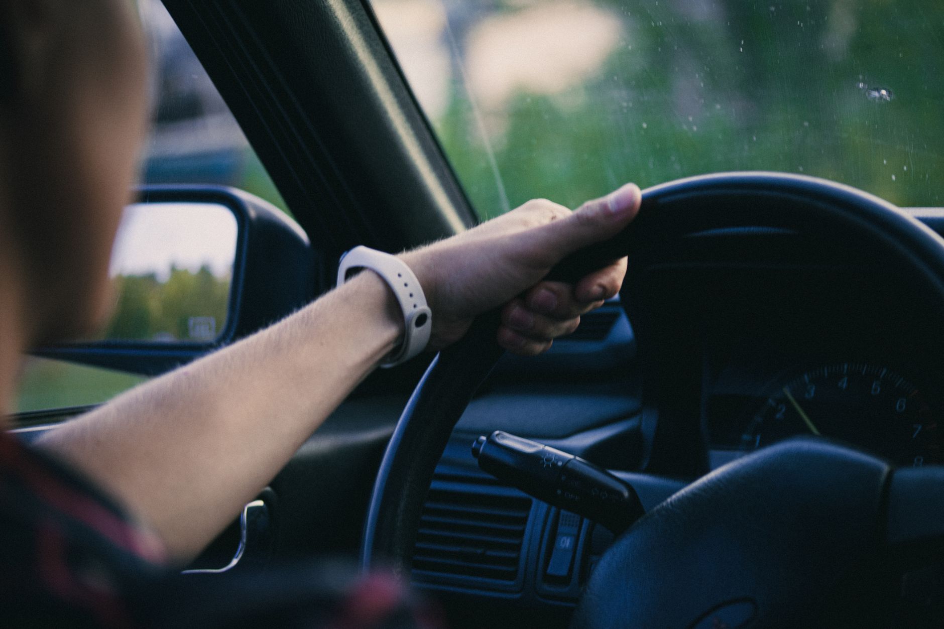 Two hands resting on a steering wheel
