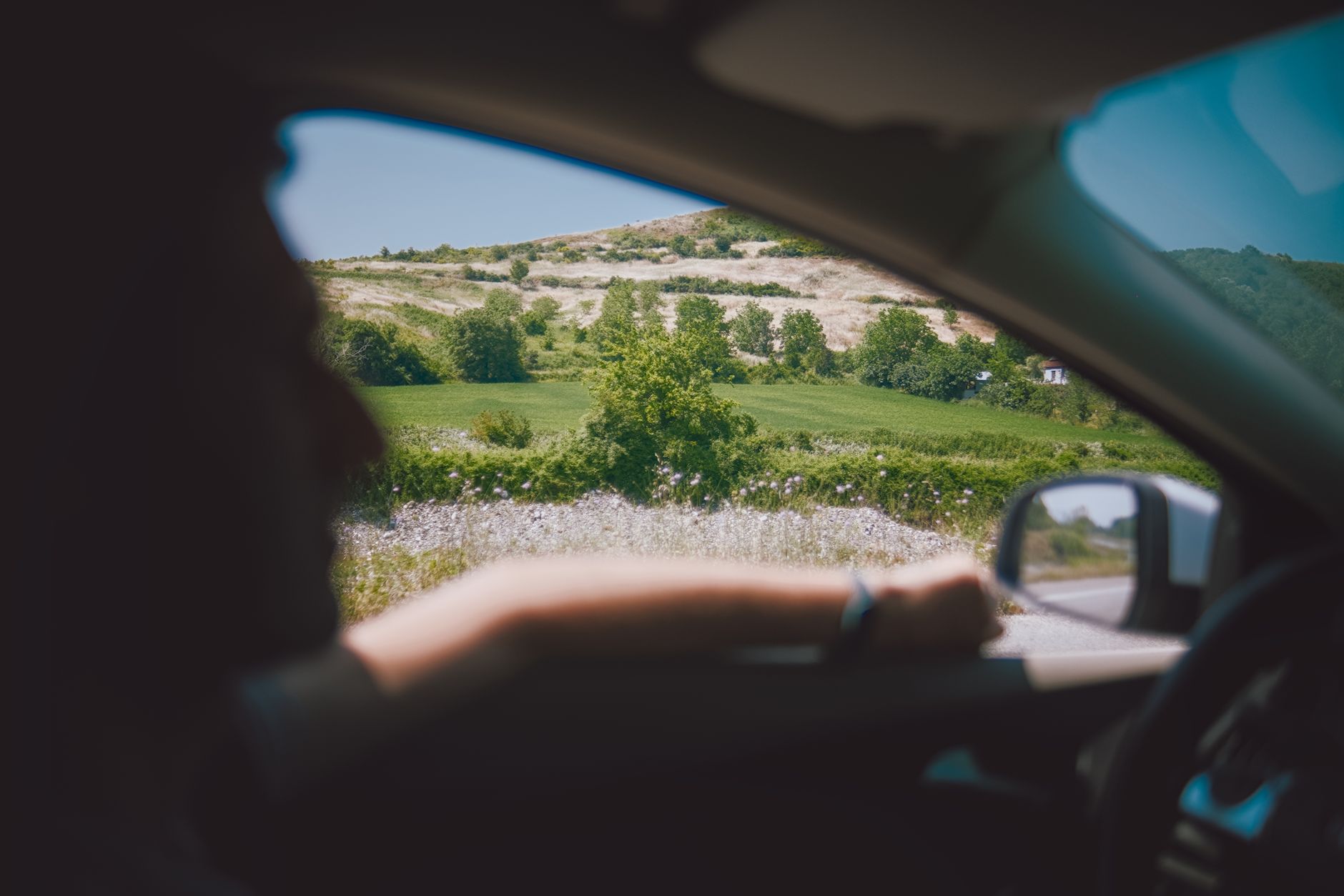 A car driving down a sunny road