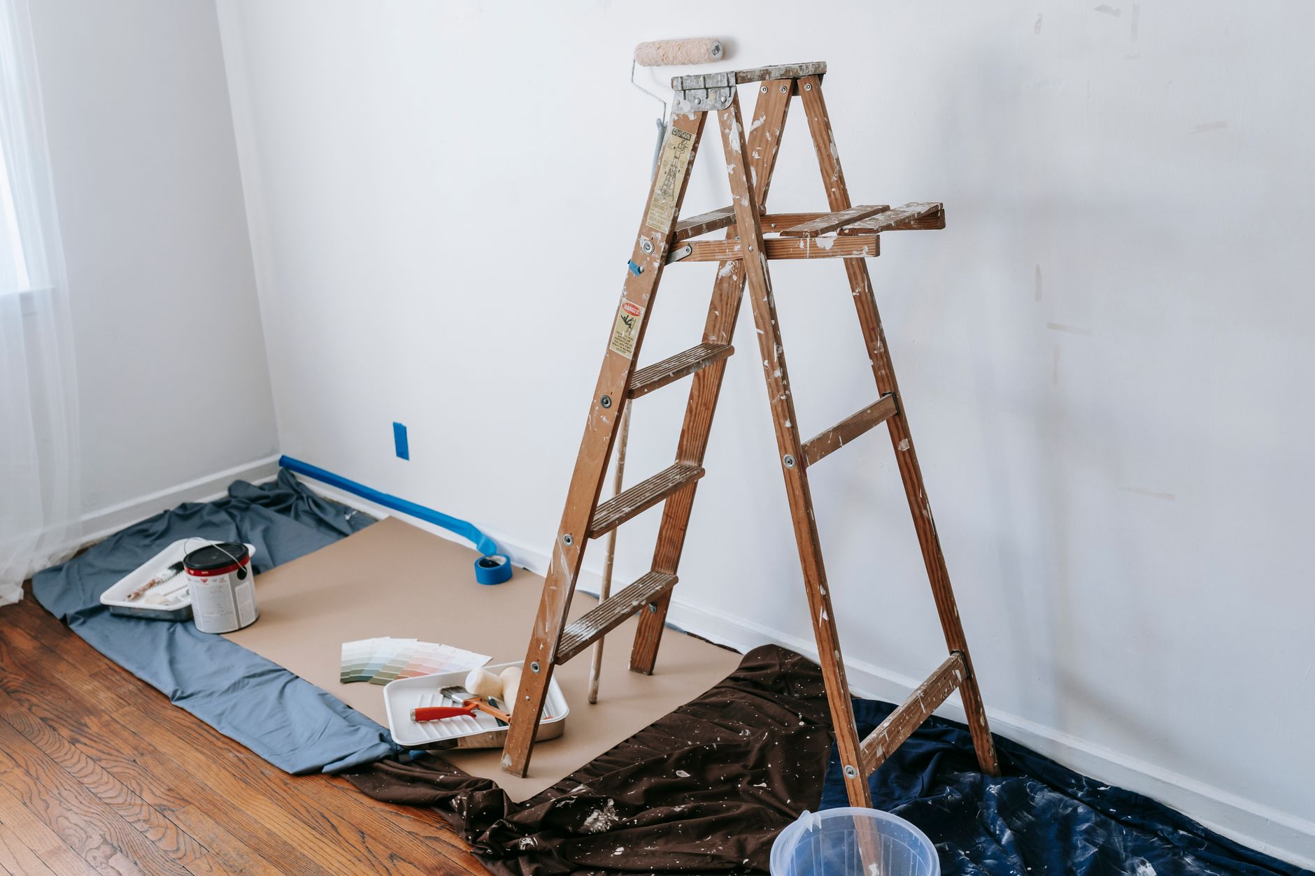 A wooden step ladder in a room being painted
