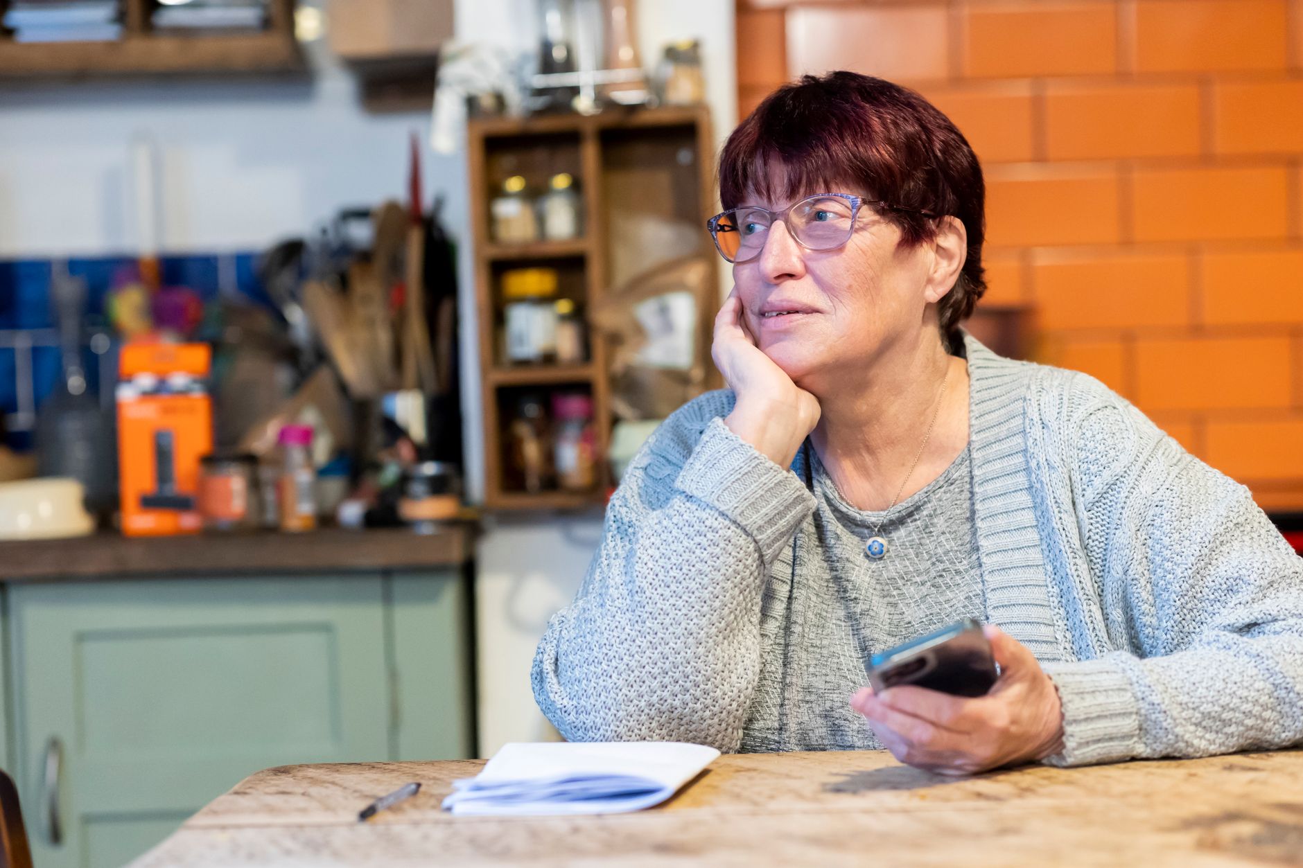 An older woman sitting at a kitchen table