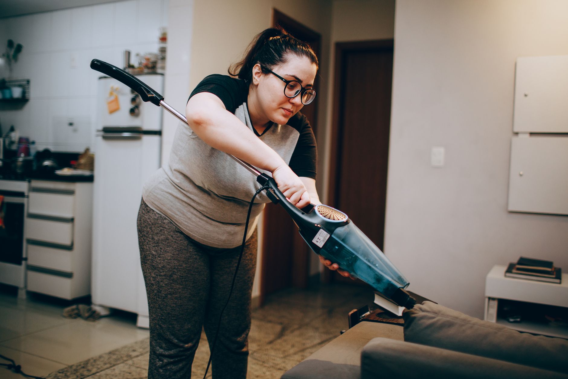 Vacuuming a sofa with a stick vacuum