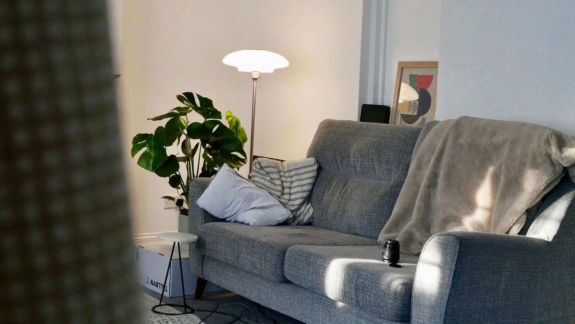 A cozy living room with a sofa and soft furnishings