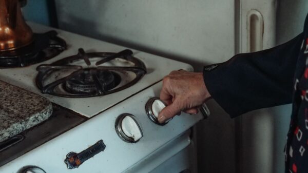 A hand turning a control knob on a gas range