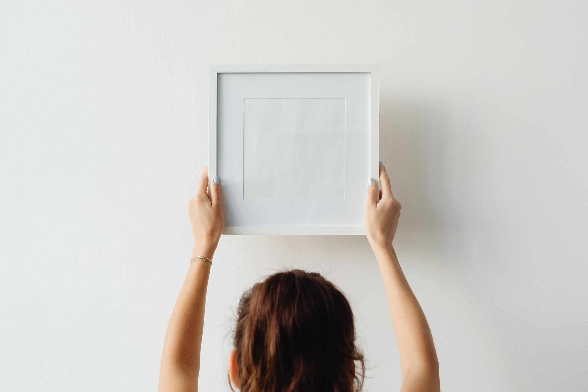 Holding a picture frame against a wall