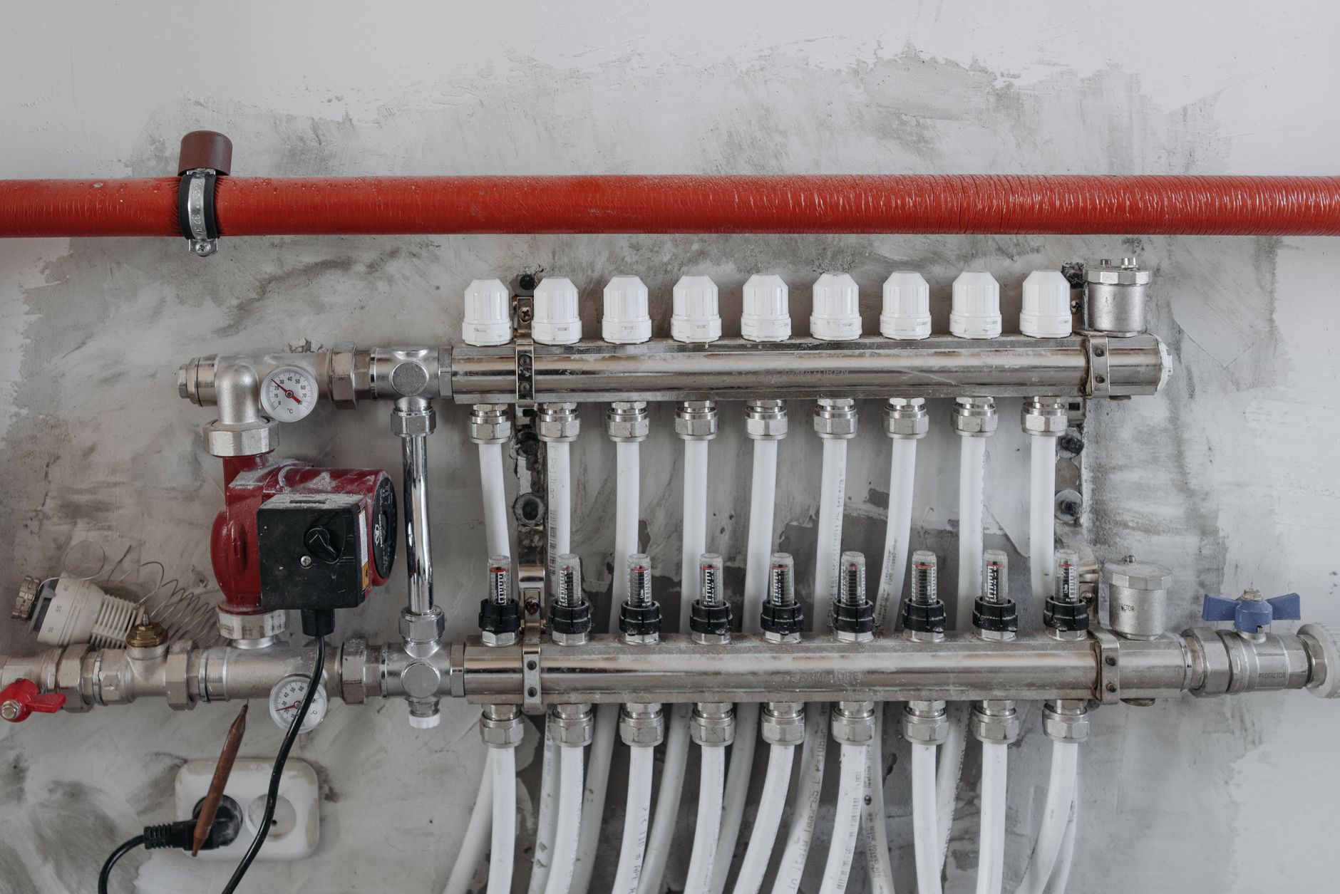 Water pipes and a manifold on a wall