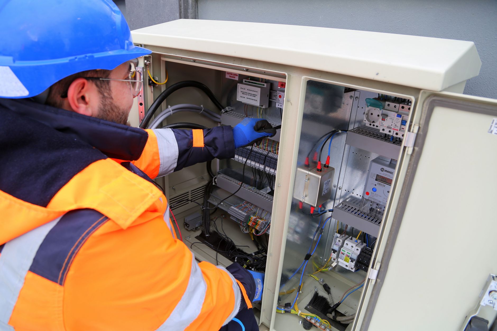 An electrician working in an electrical cabinet