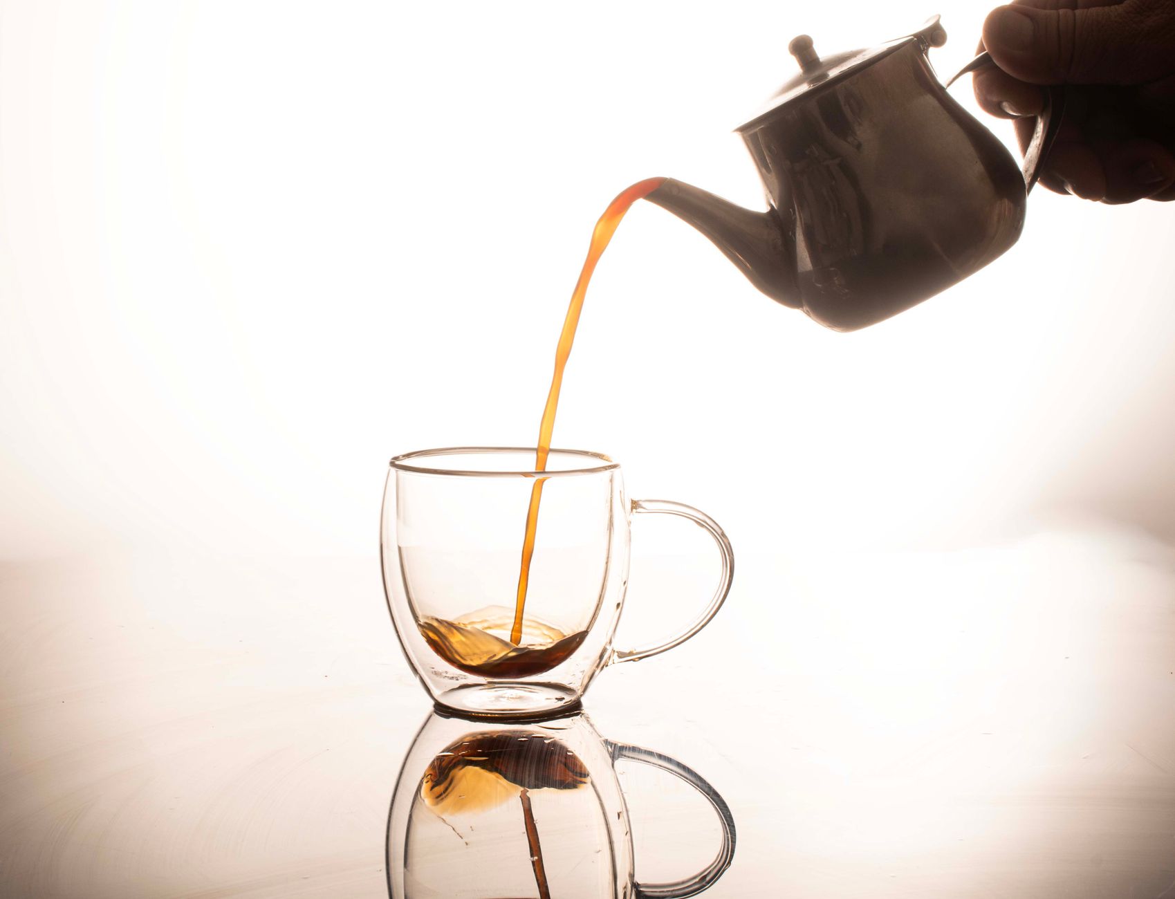Best tea maker: tea poured from a teapot into a glass cup