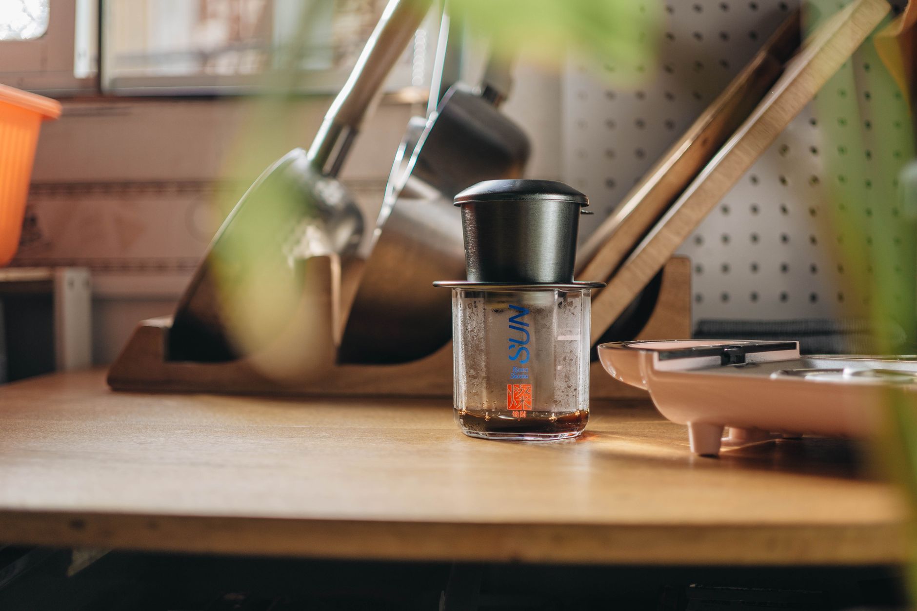 A pour-over brewer on a wooden counter