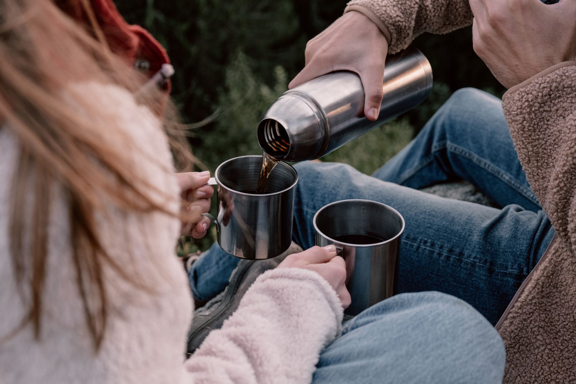 Pouring coffee from a flask outdoors