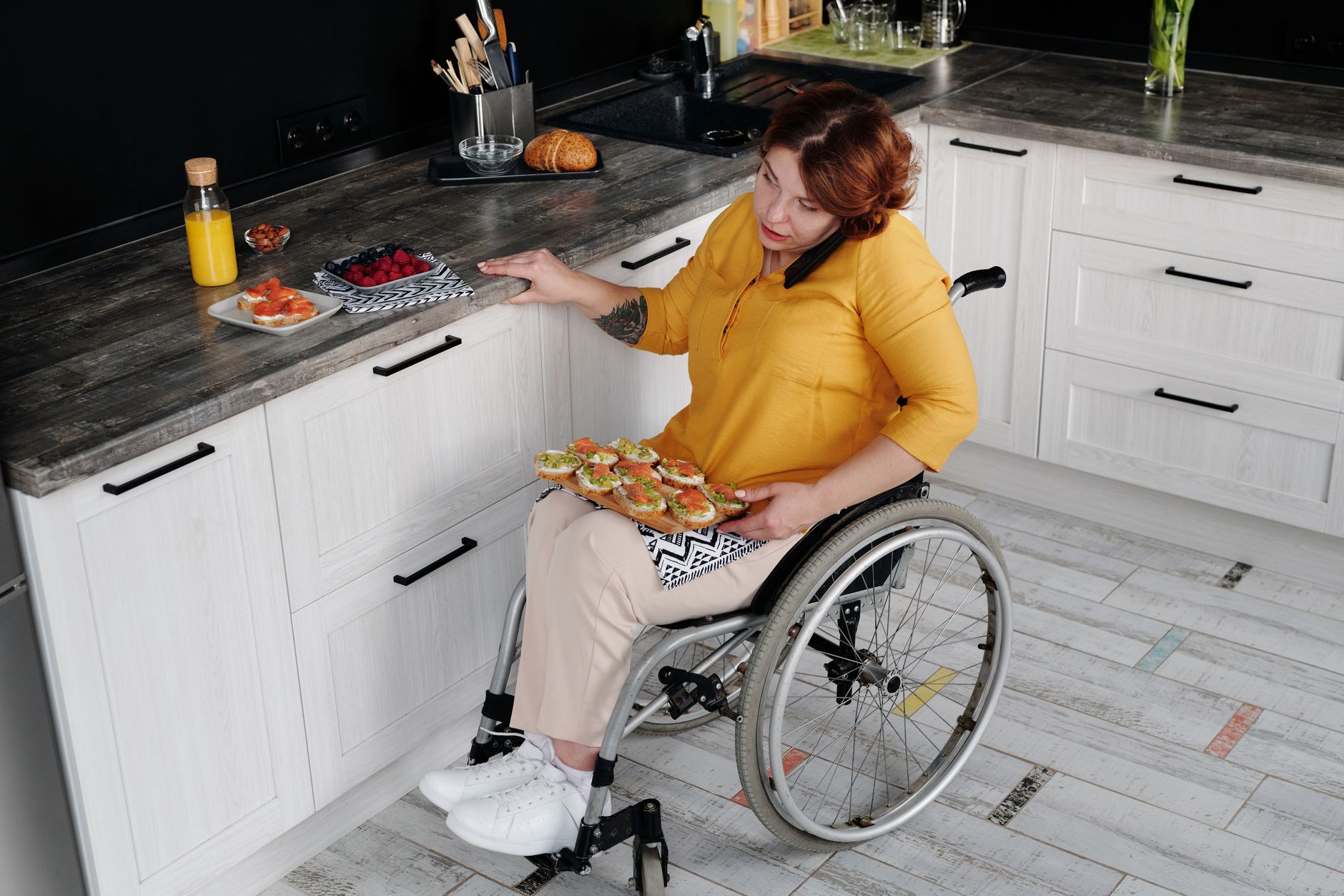 A woman in a wheelchair preparing food in her kitchen