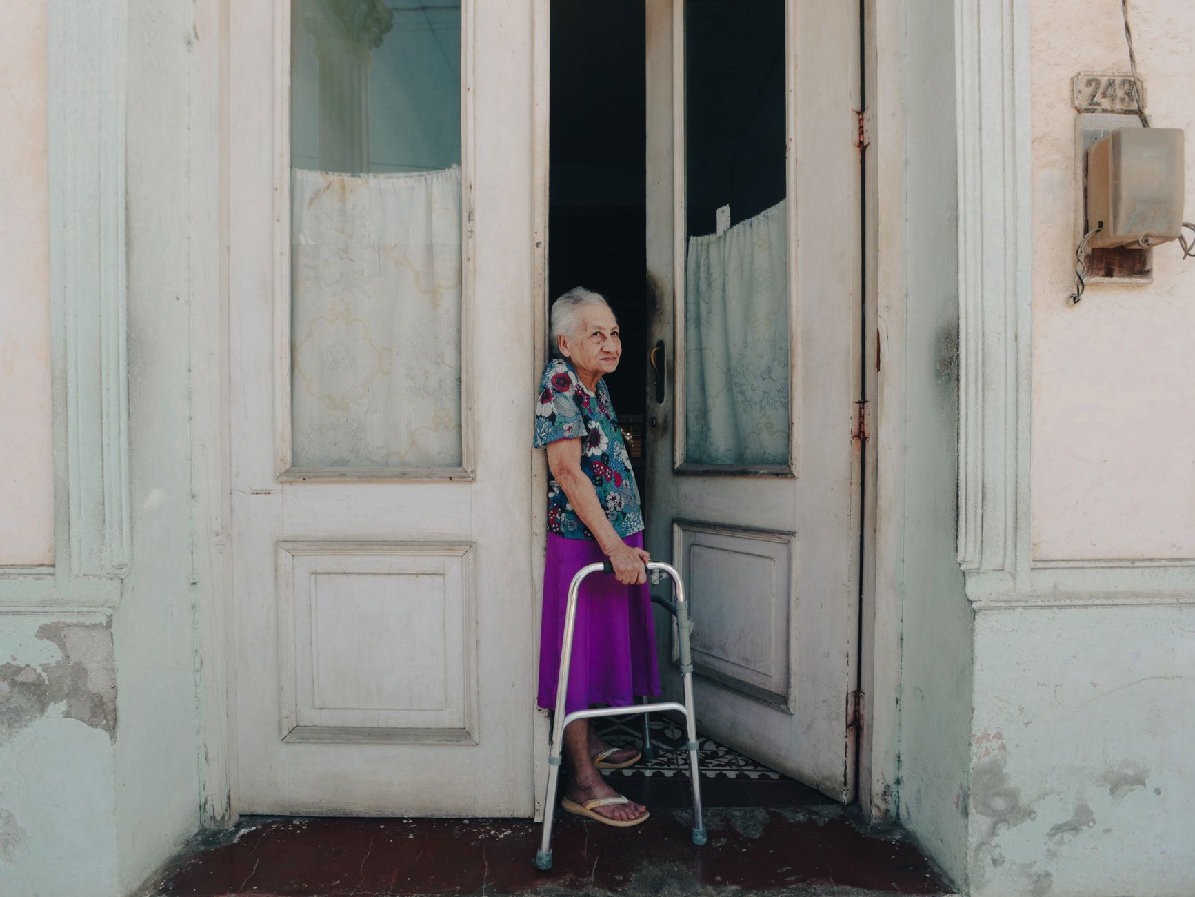 An older woman with a walker standing in a doorway