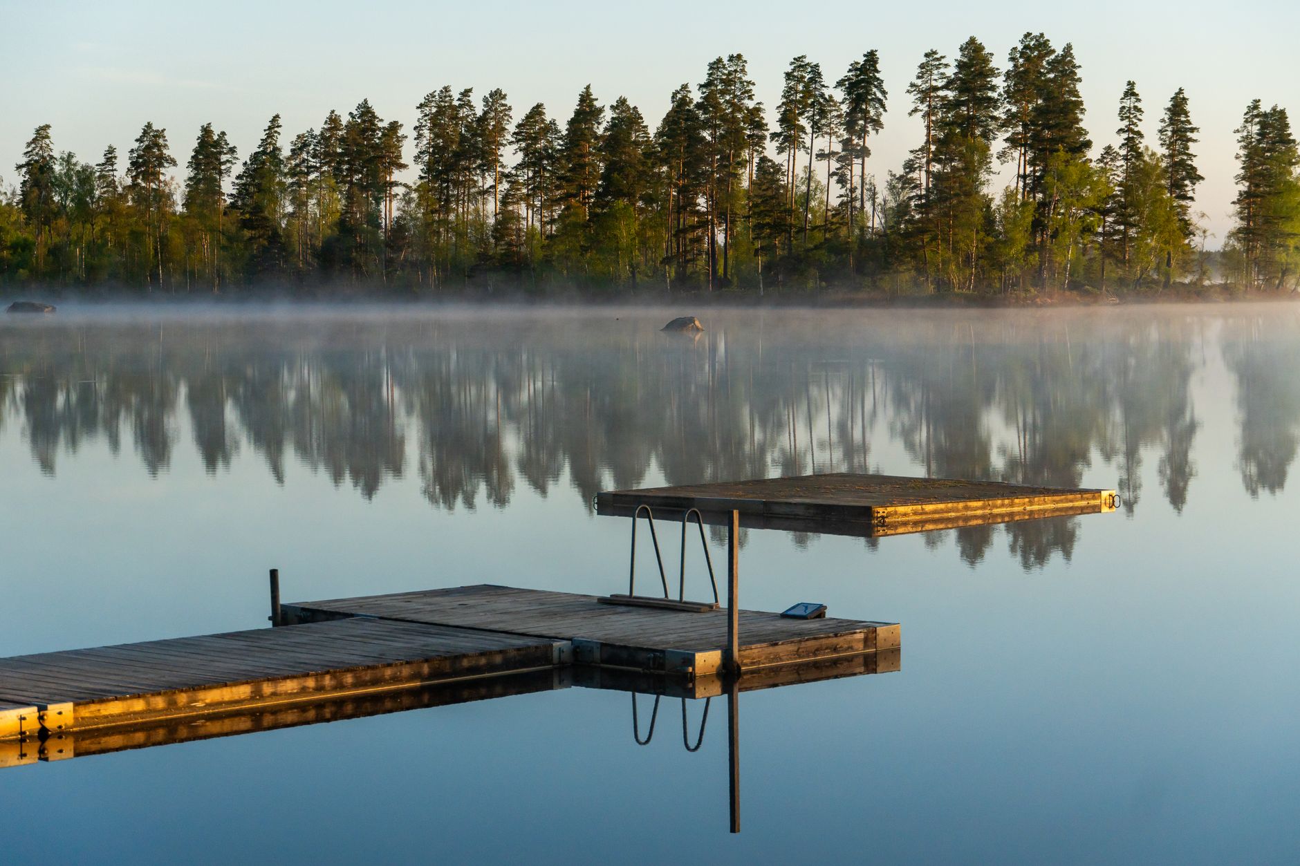 A floating dock on a misty lake