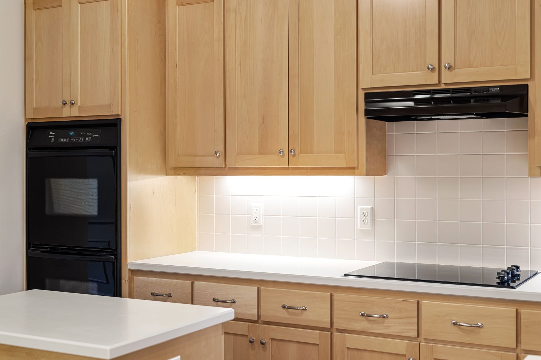 A kitchen with wall ovens and wood cabinets