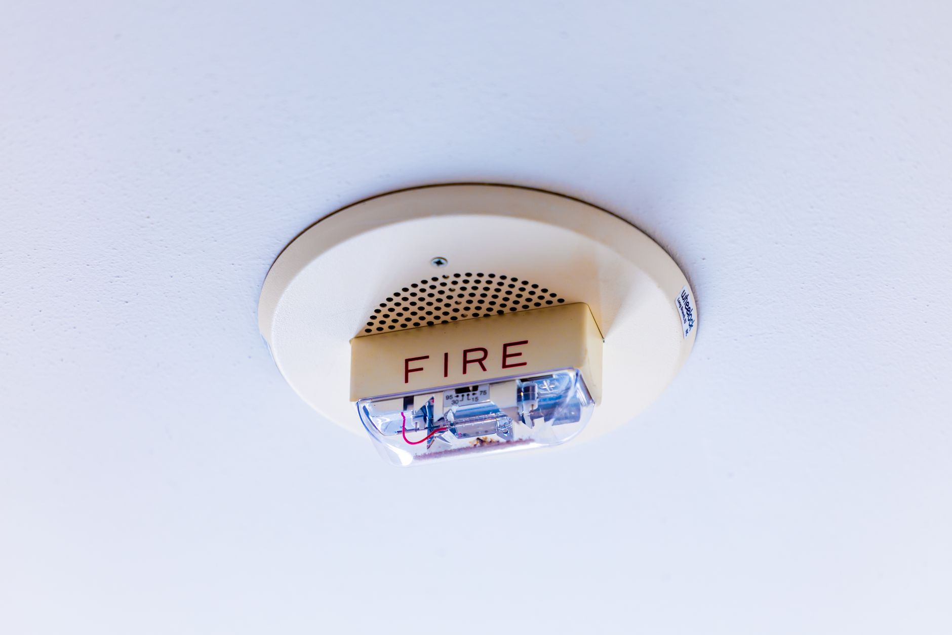 A fire alarm mounted on a ceiling