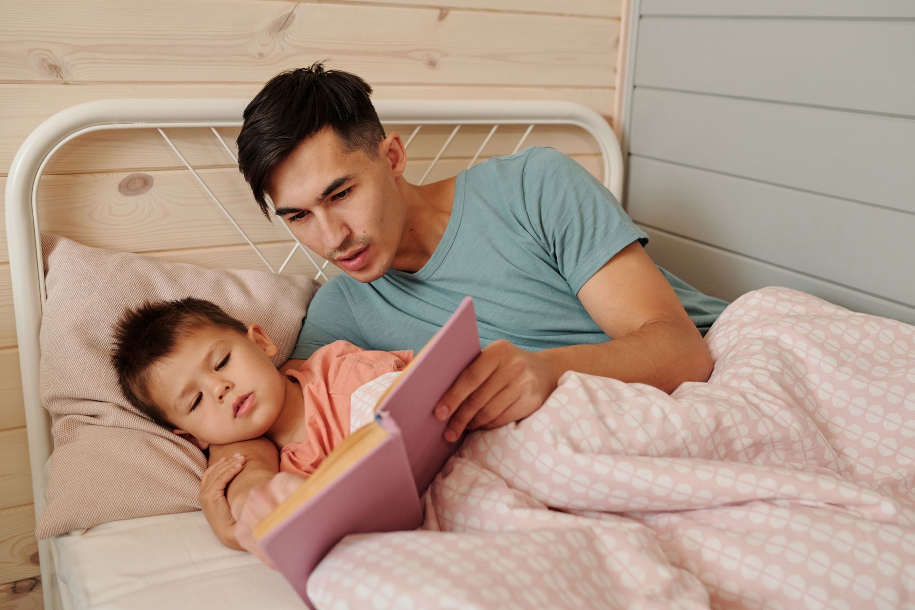 A father reading to his child in bed