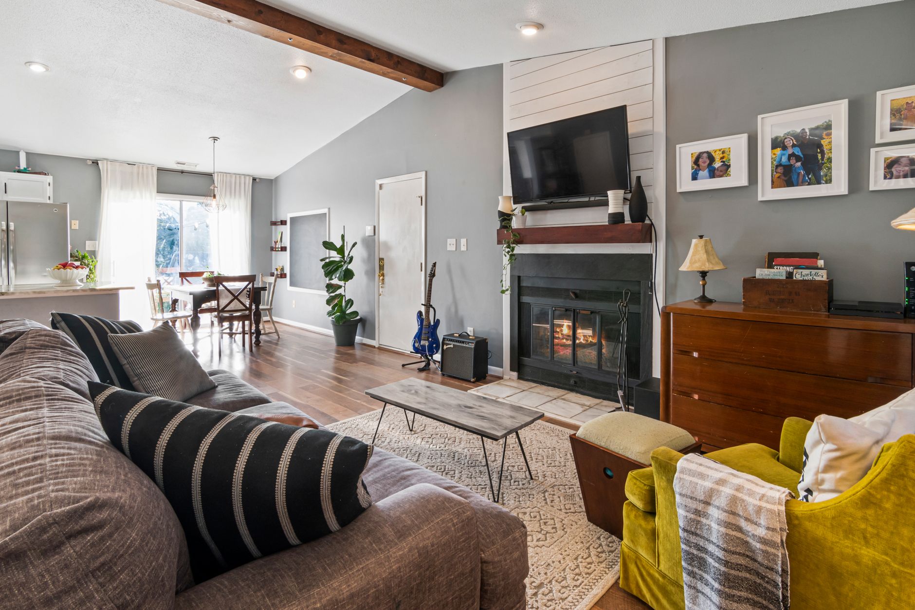 A living room with a fireplace and family photos