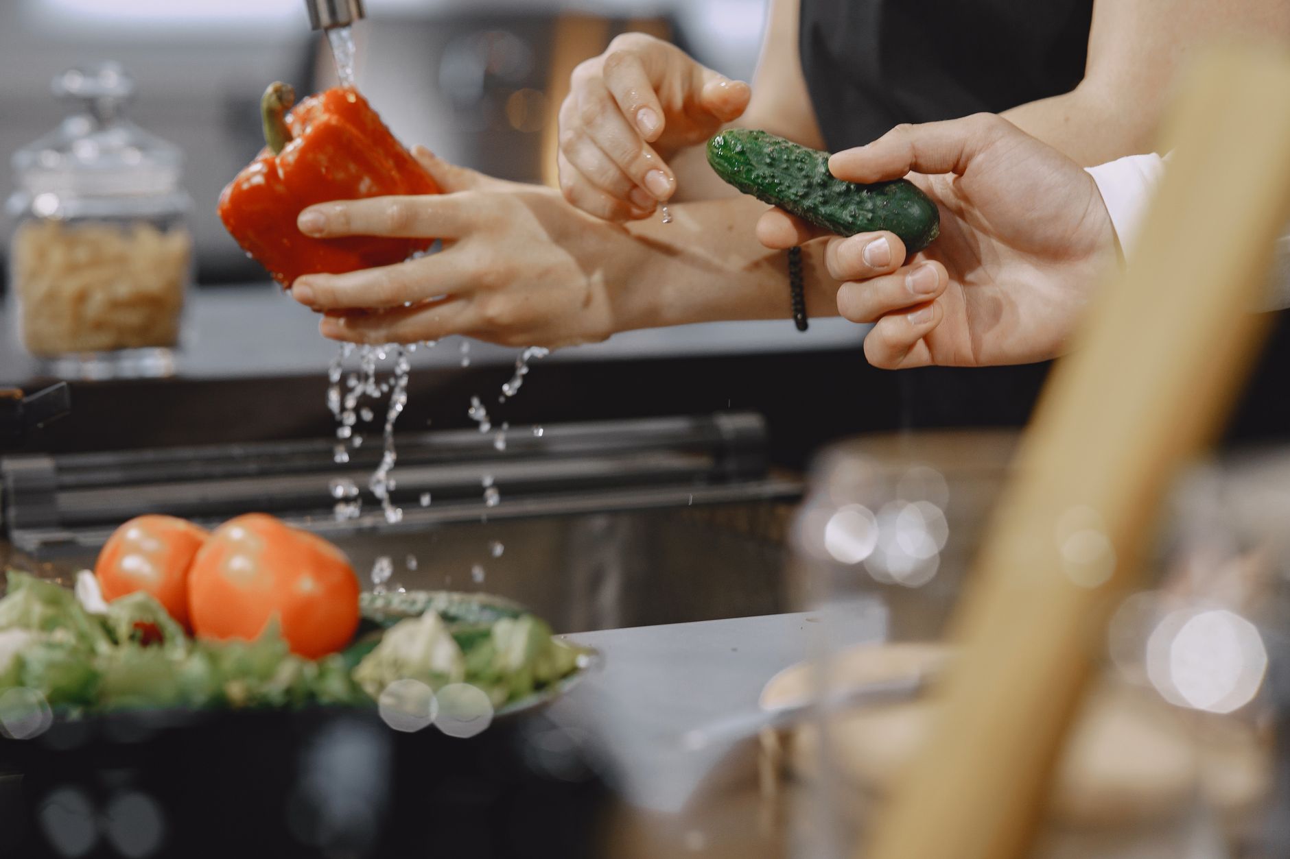 Vegetables being rinsed at a kitchen sink