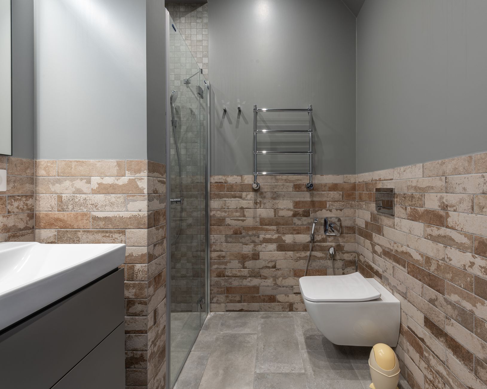 A bathroom with a towel warmer and wall-hung toilet