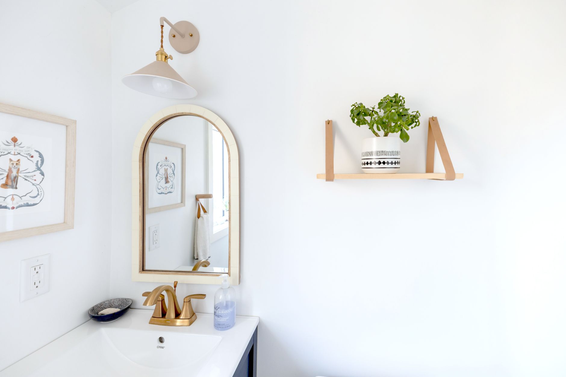 A bathroom shelf with small plants
