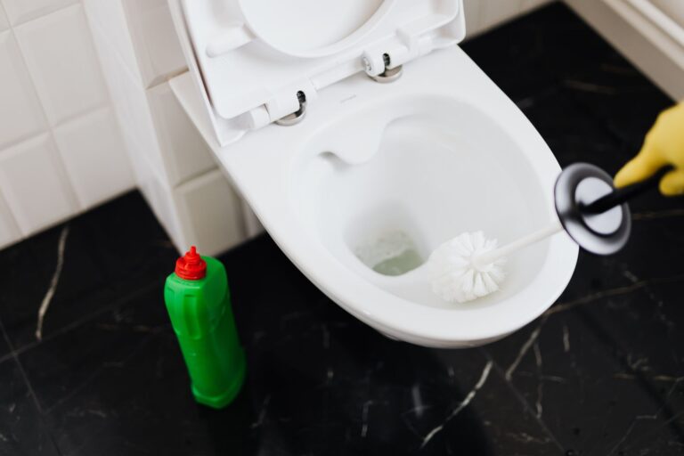 Scrubbing a toilet bowl with a brush