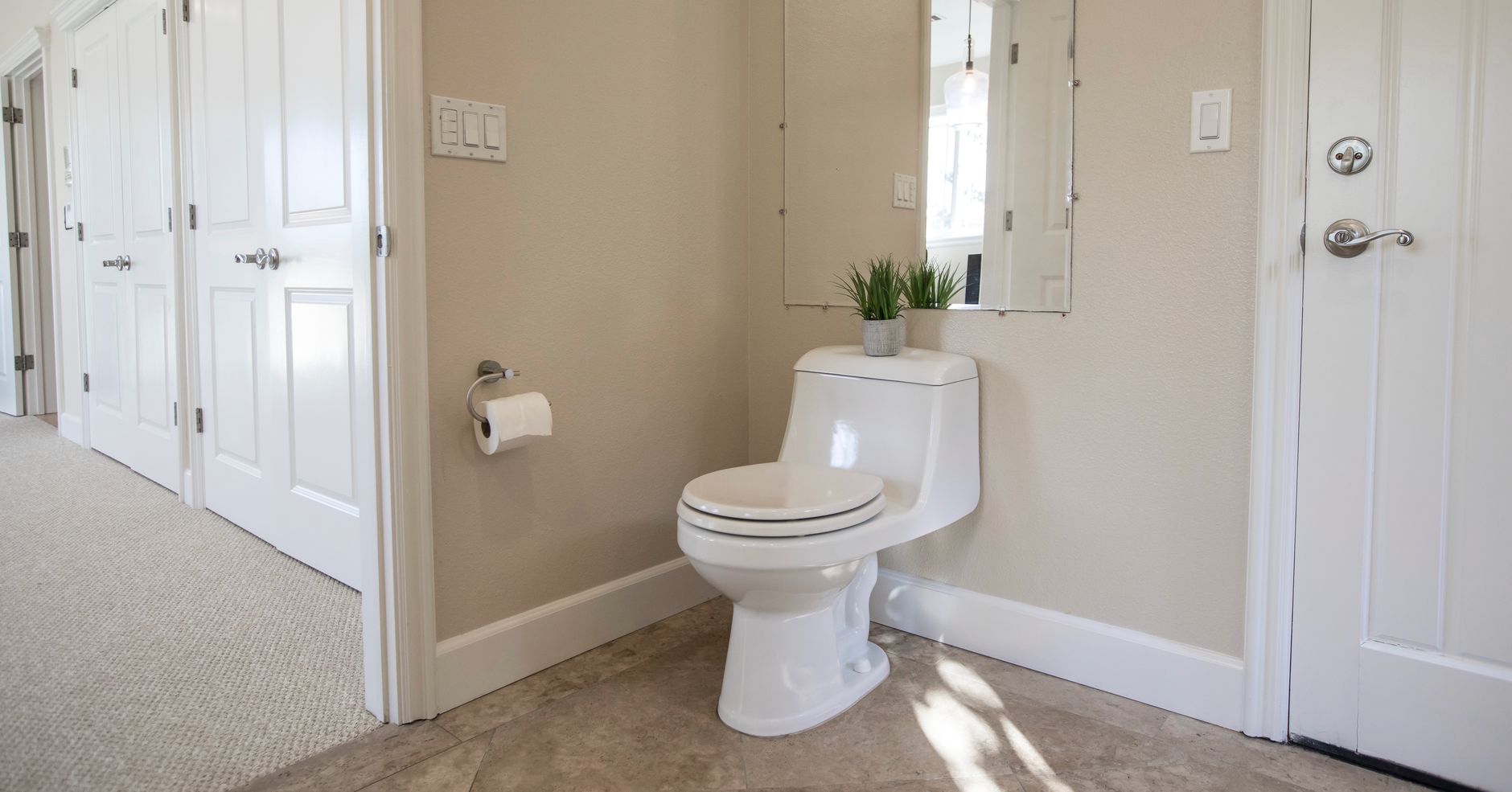 A bright bathroom with a toilet and tiled floor