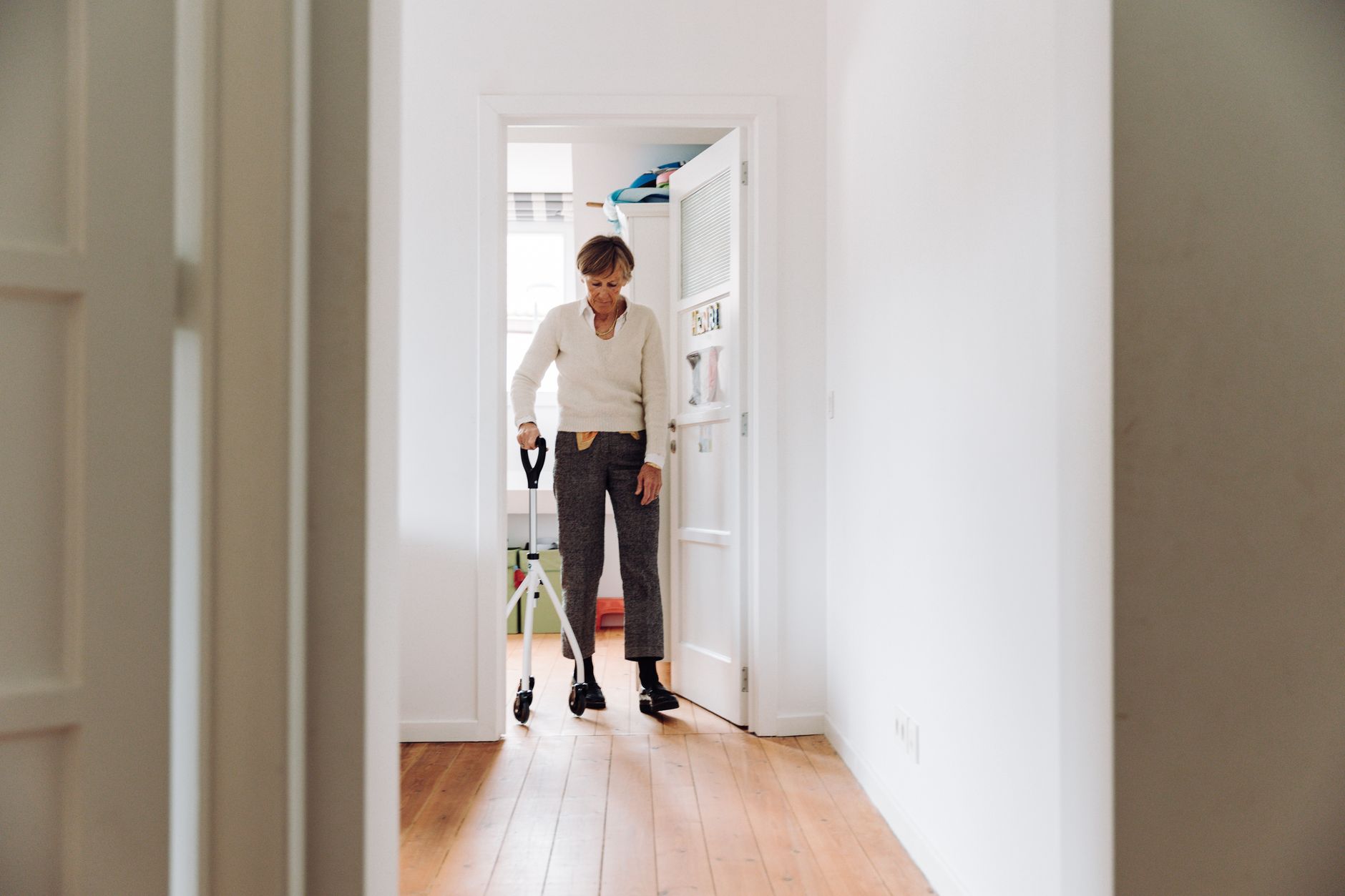 An older adult using a walker in a hallway