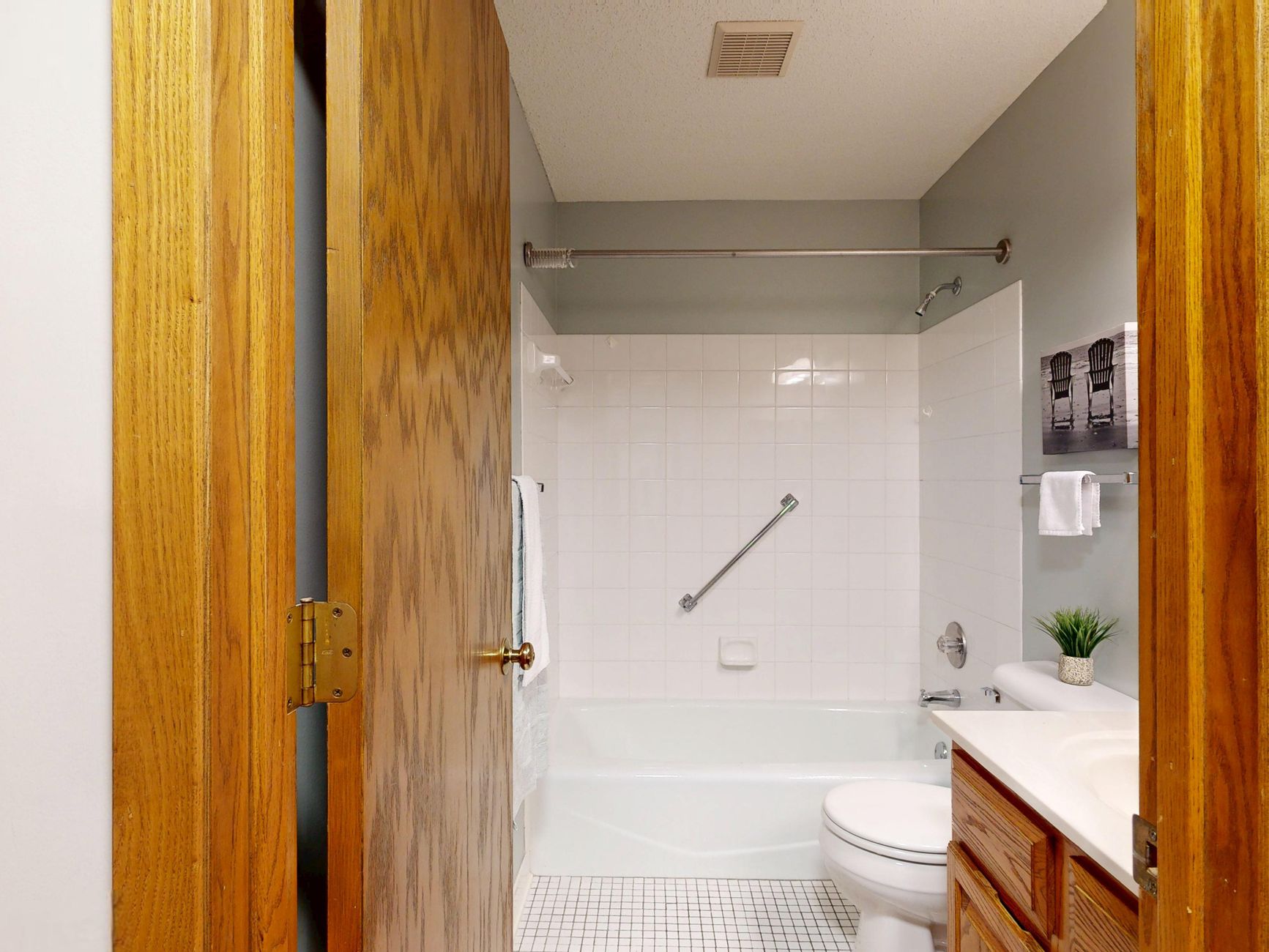 A bathroom with a grab bar mounted by the tub