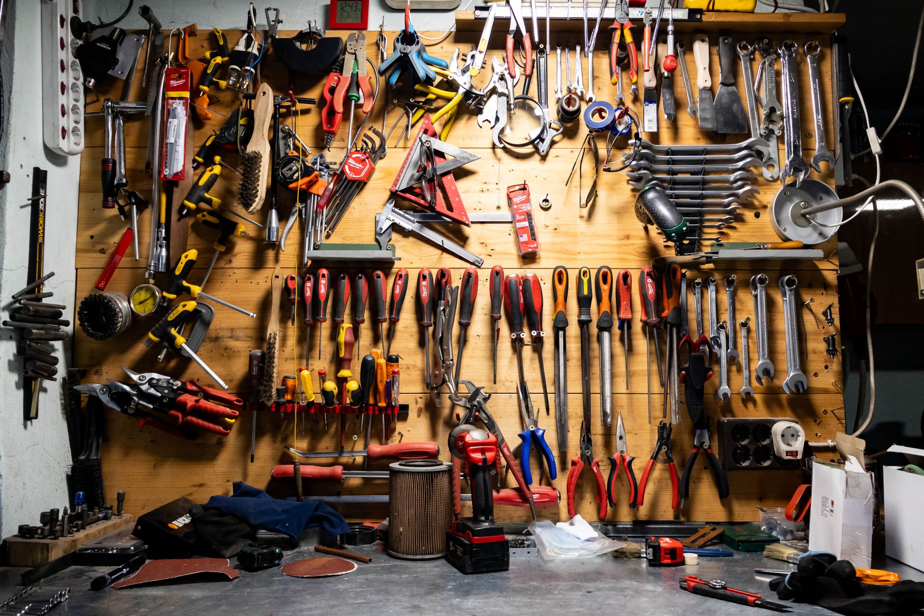 A wall of hand tools above a workbench
