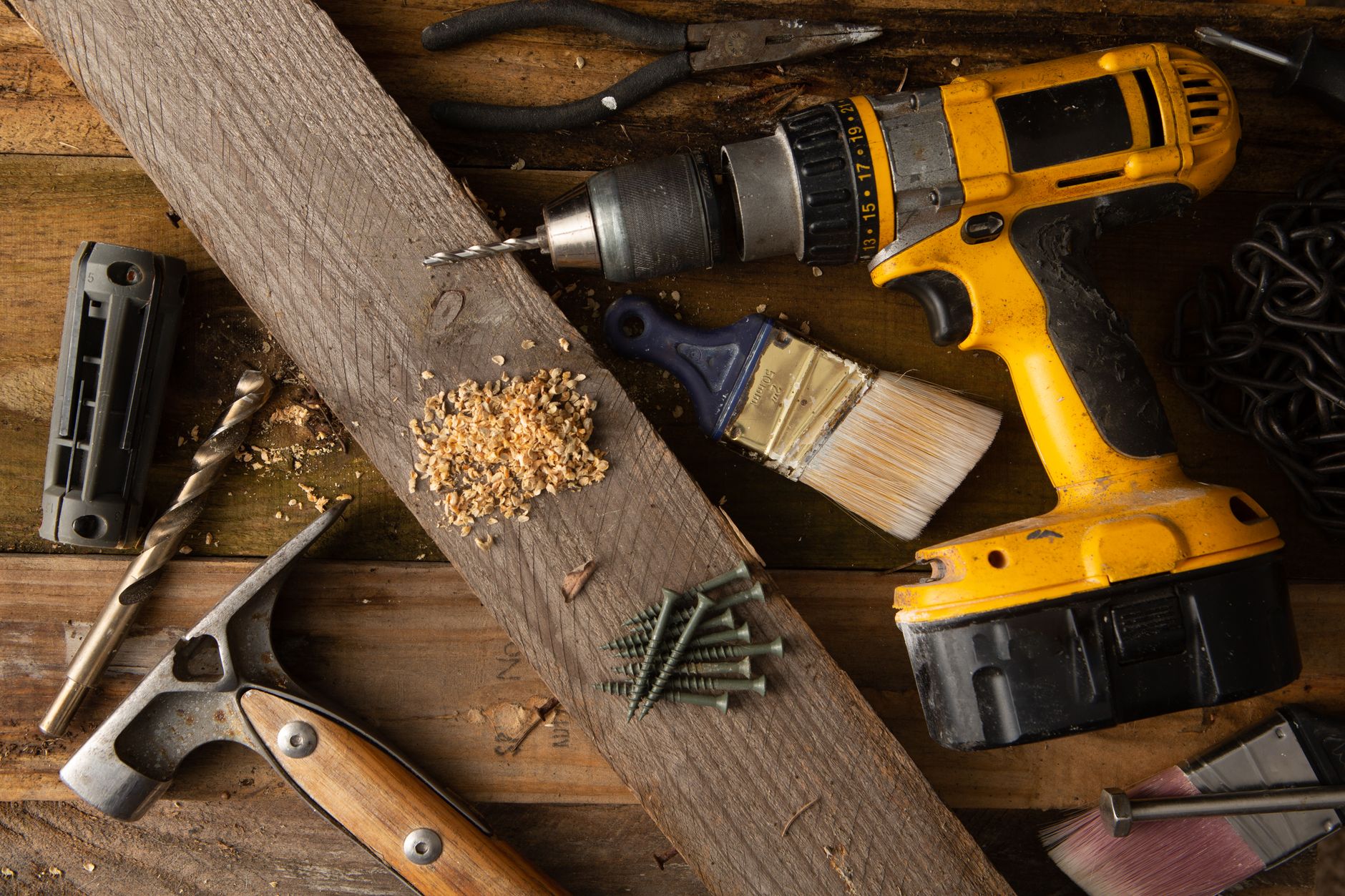 A drill, chisel and brush on wood boards