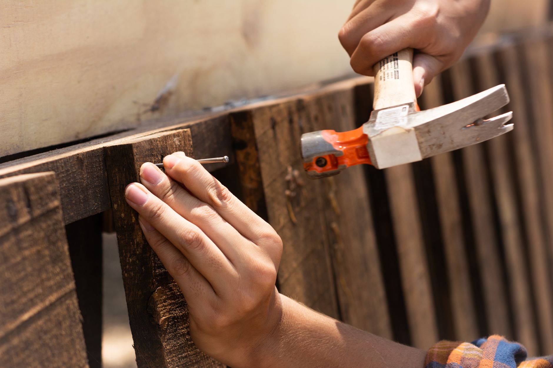Hammering a nail into a fence board