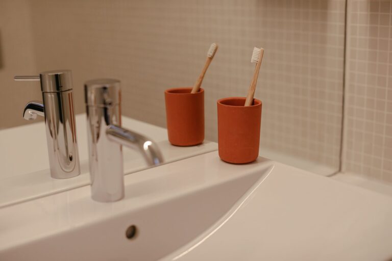 Best toothbrush holder: toothbrushes in cups beside a bathroom sink