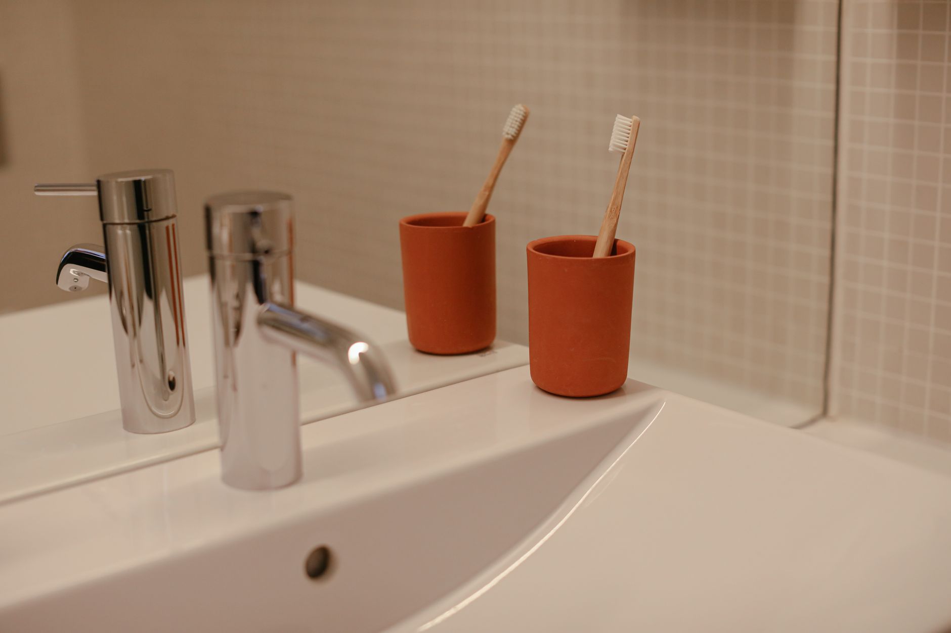 Best toothbrush holder: toothbrushes in cups beside a bathroom sink