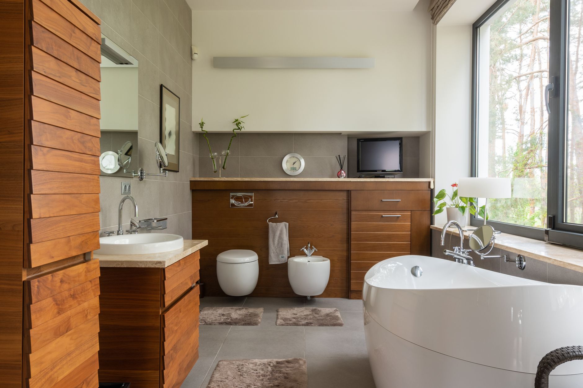 A bathroom with a freestanding tub and wood vanity