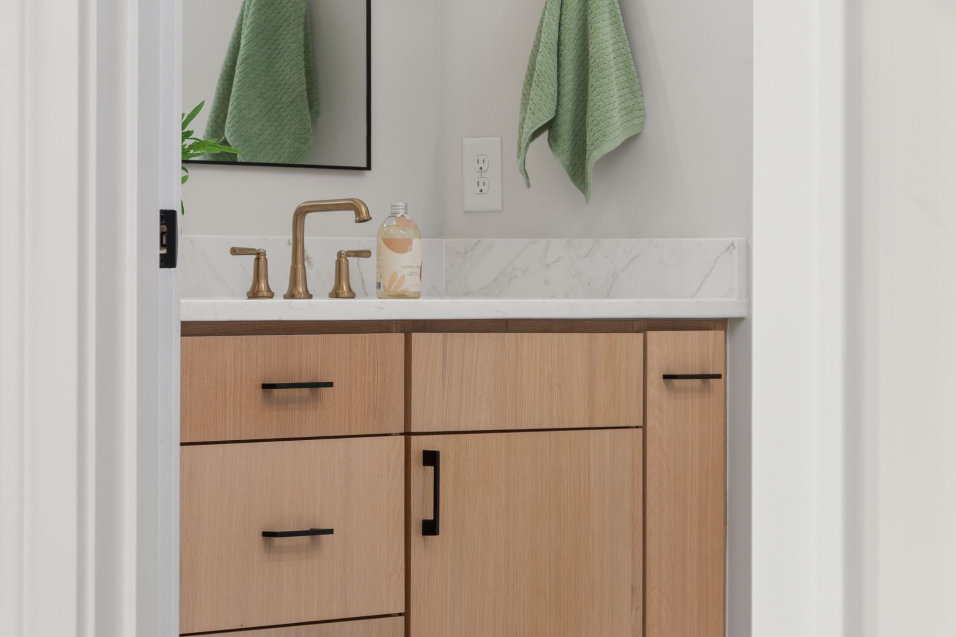 A bathroom vanity with green towels