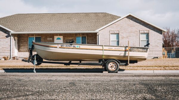 A boat on a trailer parked outside a house