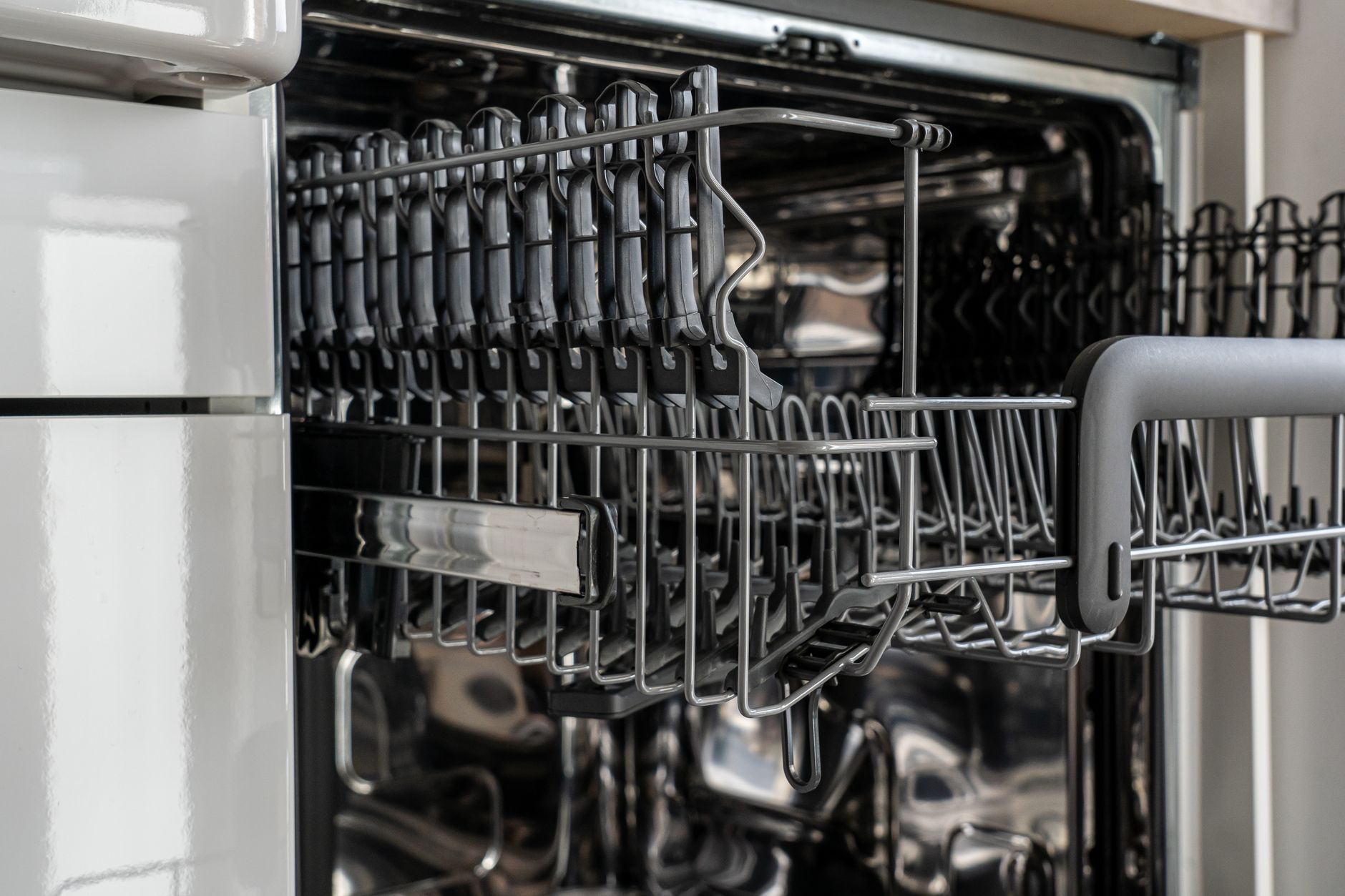 An open dishwasher rack in a kitchen