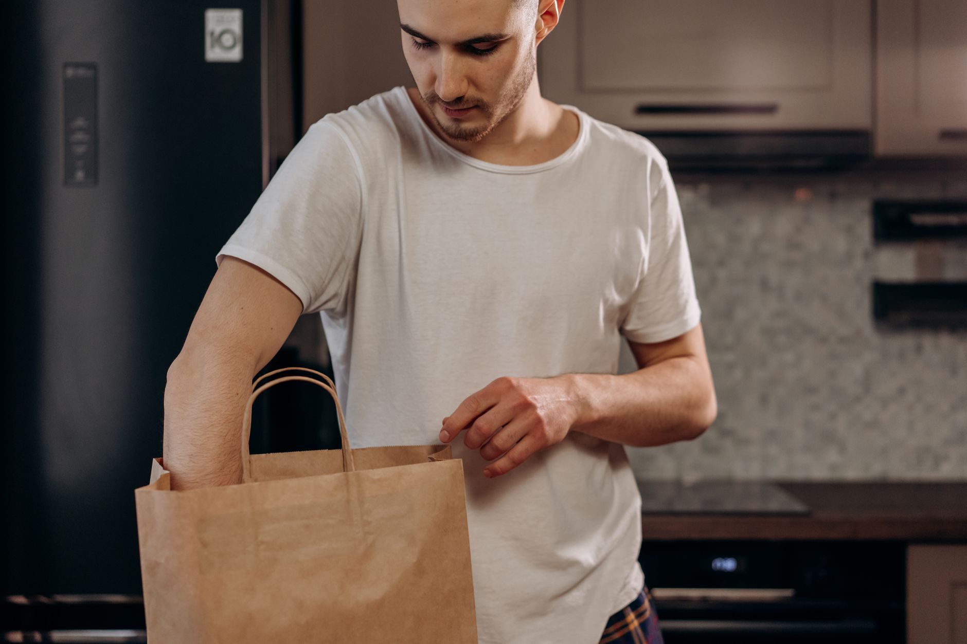 A man packing a paper grocery bag