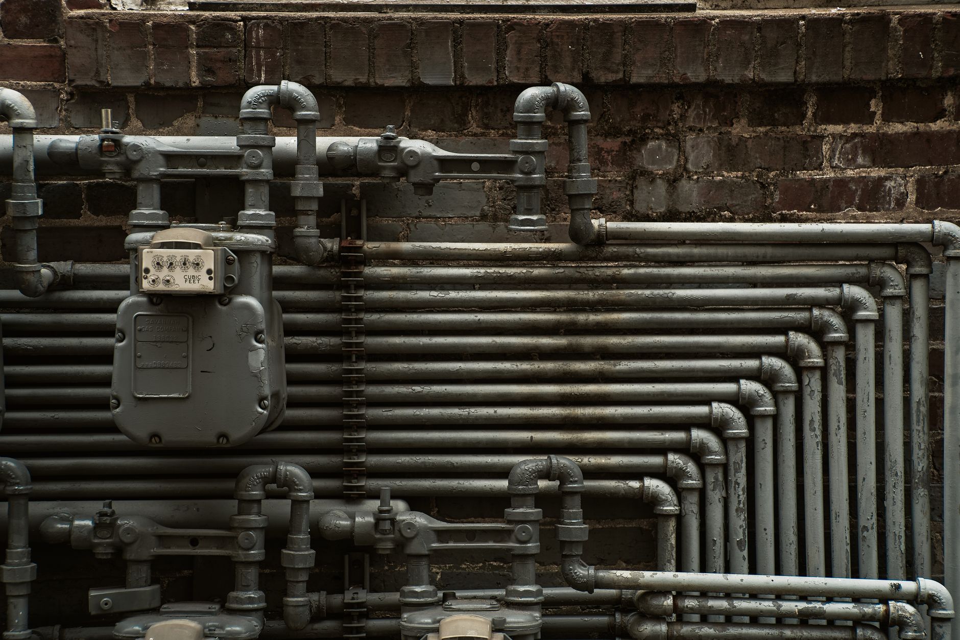 Pipes and a meter on a brick wall