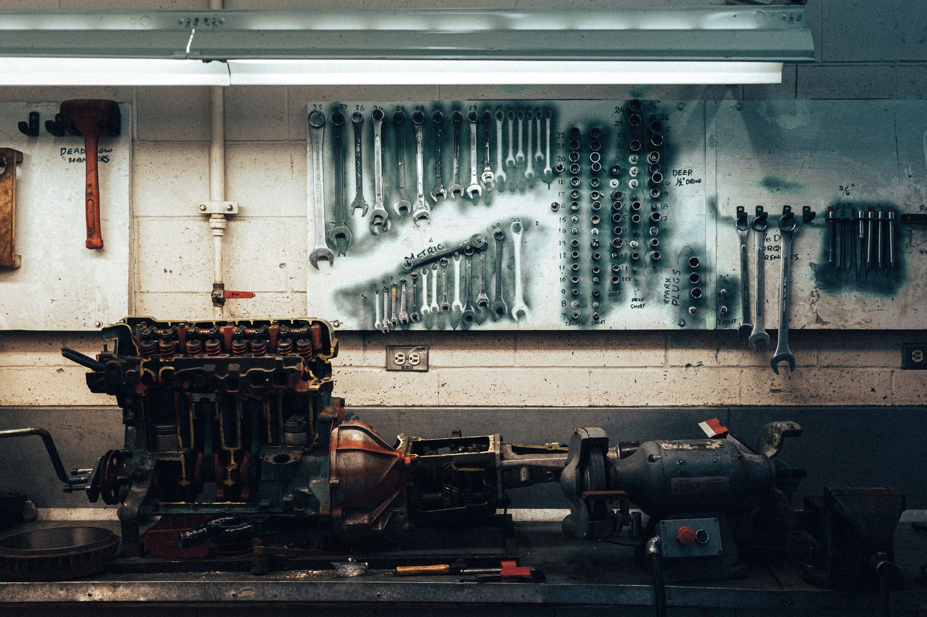 A mechanic workbench with wrenches on the wall